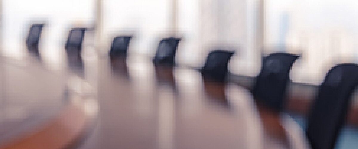 blurred image of chairs around a boardroom table
