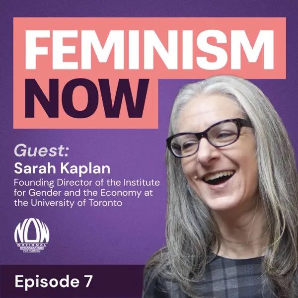 Woman with long gray hair and black-rimmed glasses smiling.