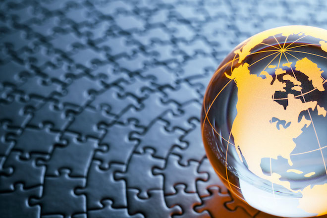 an image of a world globe sitting on a set of puzzle pieces